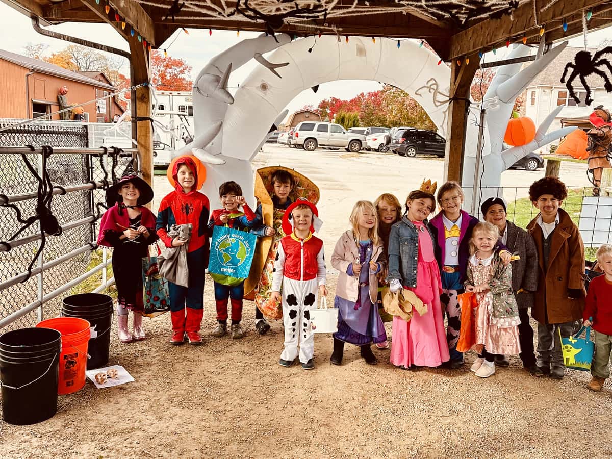 Children in costume gathered under the decorated pavilion at the farm